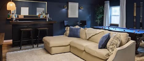 Game room with bar, pool table, and 65" TV for fun and relaxation.
