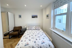 Double bedroom with leather chair, wardrobe. Access to en-suite with toilet & shower