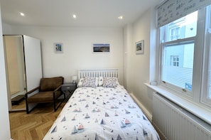 Double bedroom with leather chair, wardrobe. Access to en-suite with toilet & shower