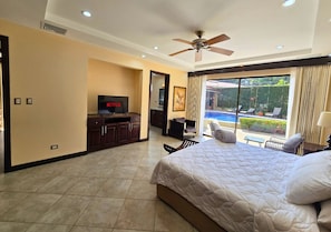Master with ensuite, smart TV, and patio access for poolside relaxation.