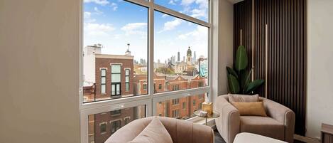 Living Room: Stunning city views await in this stylish retreat with elegant furniture!