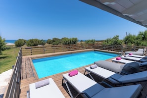 Pool area with luxurious sunbeds and sea views.