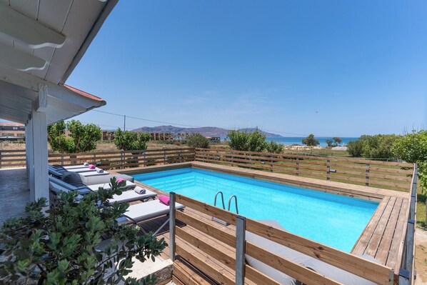 Pool area with luxurious sunbeds and sea views.
