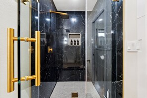 Step into relaxation with this stunning walk-in shower, featuring sleek marble finishes and a rain shower head. Perfect for unwinding after a day spent exploring the local attractions, like the Richardson Zoo.