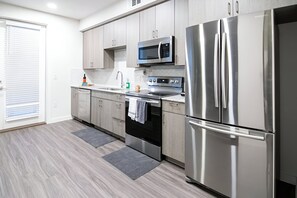 Sleek and modern kitchen with stainless steel appliances and ample counter space. Perfect for preparing meals and enjoying time together.