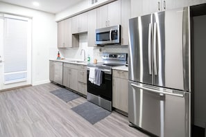 Sleek and modern kitchen with stainless steel appliances and ample counter space. Perfect for preparing meals and enjoying time together.
