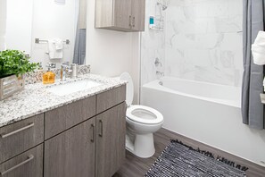 Clean and modern bathroom with a spacious shower and fresh towels. Perfect for a refreshing start to your day.