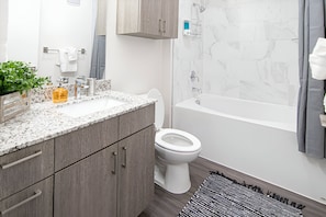 Clean and modern bathroom with a spacious shower and fresh towels. Perfect for a refreshing start to your day.