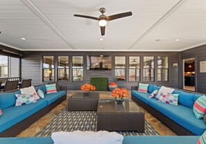 Amazing large screened in porch with large sectional, a TV & plenty of seating options. 