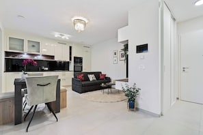 Stylish Dining & Living Area – Enjoy meals at the chic dining table for two, with large windows that fill the space with natural light.