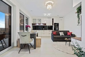 Bright & Open Living Space – Relax in the contemporary living room with a plush sofa, Smart TV, and elegant décor for a cozy atmosphere