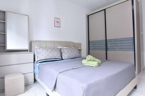 A bedroom with a queen-sized bed and plush pillows.