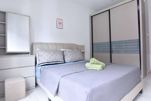 A bedroom with a queen-sized bed and plush pillows.