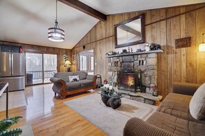 Warm and inviting living room with a stone fireplace, rustic wood accents, and cozy seating—perfect for relaxing after a mountain adventure!