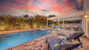 Lounge beneath fans on the shaded patio as fountains bubble and palms sway—relaxation, day or night.