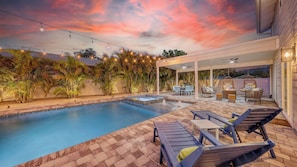 Lounge beneath fans on the shaded patio as fountains bubble and palms sway—relaxation, day or night.