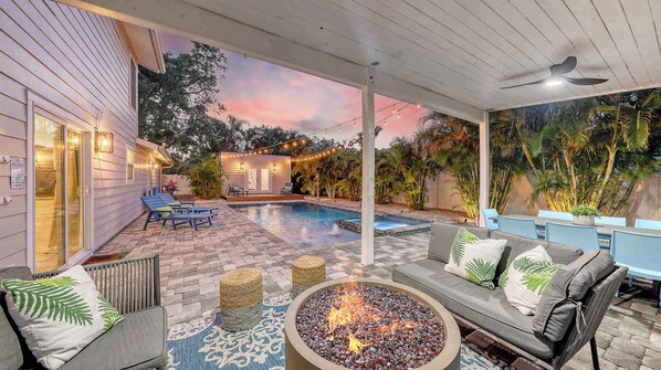 Evenings glow with firelight and string lights as the palm-lined pool transforms into your own private resort.