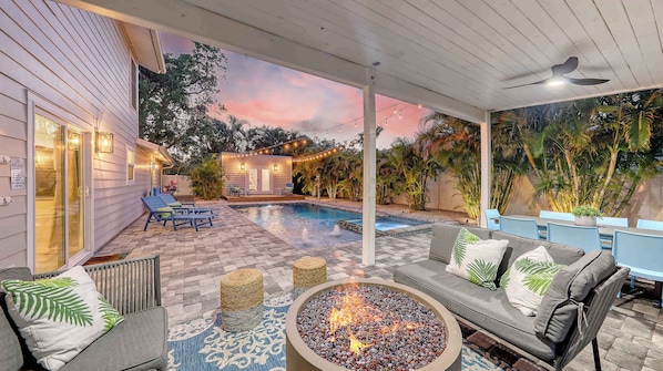 Evenings glow with firelight and string lights as the palm-lined pool transforms into your own private resort.