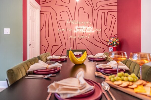 Dine in style with a Pittsburgh touch! ✨ Enjoy a beautifully set table, cozy seating, and a neon glow that sets the perfect vibe. Whether it’s a special dinner or game night, this space is made for unforgettable moments! 🍽💛