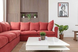 Luxe living room with wood panels, open kitchen, 75" TV, and air conditioning.