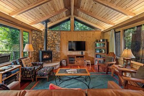 You'll love gathering in the lodge-like living room with a stone hearth and open beamed, vaulted ceilings.