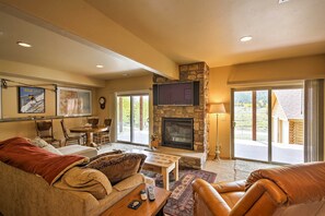Spacious living area with stone fireplace and sliding glass doors
