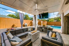 TEXAS SIZED outdoor area with lots of seating, BIG ASS fan, 60" Smart TV that rotates 360 degrees, dinning, BBQ Gas Grill, Fire pit, Hot Tub, Heated Pool and lots of outdoor games