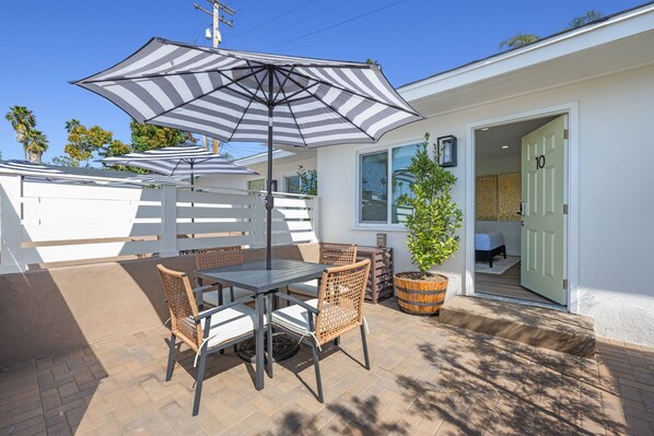 Enjoy your semi-private patio, featuring a table and umbrella, where you can relax and embrace the refreshing ocean breeze.