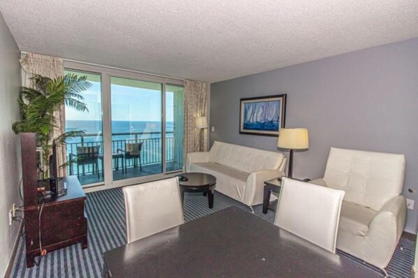 Bright and cozy oceanfront living room with stunning balcony views