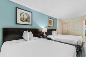 Bedroom with two beds, soft lighting, and modern artwork