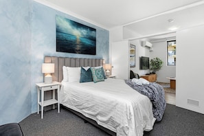 Unwind in a serene bedroom, showcasing a calming blue accent wall, plush bedding, and contemporary décor.
