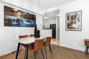 Enjoy meals in a stylish dining area, featuring modern furniture and captivating artwork for a sophisticated touch.