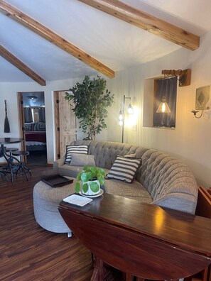 Round couch is comfy, is facing the fireplace and small TV,  + near the kitchen.