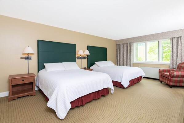 Spacious room with ample natural light and cozy beds, perfect for a restful stay.