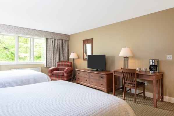 Bright and inviting bedroom with a cozy seating area, ideal for unwinding and enjoying the peaceful surroundings.