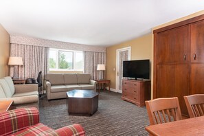 Unwind in the spacious living area, complete with comfortable seating and an inviting atmosphere for conversation and relaxation.