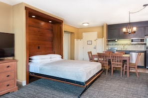 This versatile layout offers a blend of comfort and function, with a cozy bed and well-equipped kitchen for an all-in-one living experience.