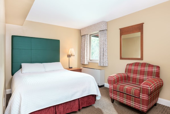 Inviting bedroom featuring a plush bed and a cozy armchair, perfect for a peaceful retreat after a long day.