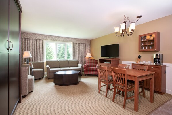 Spacious living and dining area with a cozy fireplace and large windows, perfect for gathering and enjoying the natural light.