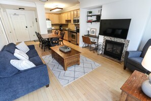Inviting living room with comfortable seating, a fireplace, and a flat-screen TV for relaxation and entertainment.