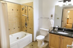 Clean and modern bathroom featuring a shower-tub combo and sleek finishes for convenience and comfort.