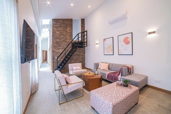 Living room, stairs are used to access mini bedroom on mezzanine.