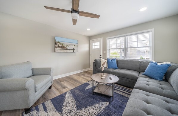 Living Room: Bright and airy retreat with sleek furnishings and charming coastal decor awaits!