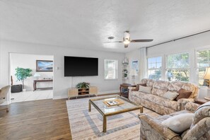 Open living room with 72" Roku TV and comfy reclining couches