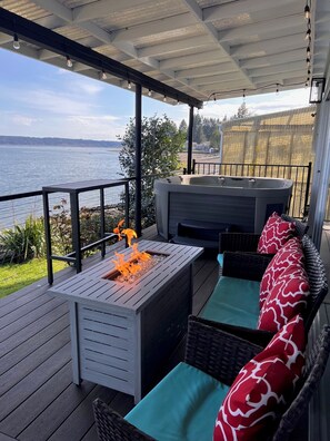 The deck is set up with patio furniture, dining table, hot tub, bbq. 