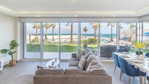 Expansive living room is bounded by floor to ceiling windows.