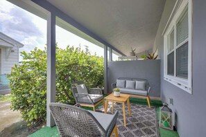 Unwind on the covered patio surrounded by lush greenery. The seating area is perfect for sipping morning coffee or enjoying evening breezes.