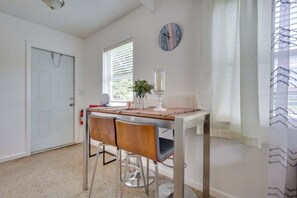 Start your day in this cozy dining space, featuring a modern table with bar stools, soft natural lighting, and elegant decor for a comfortable meal experience.