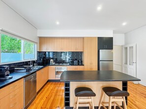 Open plan kitchen with stainless steel cooking & dishwasher