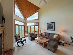 The main living room boasts mountain views, a gas fireplace and TV and is an open layout with the dining and kitchen areas.